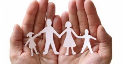 Mãos amparando um recorte de papel representando a família