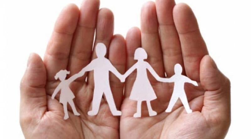 Mãos amparando um recorte de papel representando a família